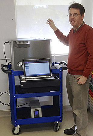 Dr Philip Sharpe with his Spinsolve NMR spectrometer on a trolley for easy movement between laboratories.
